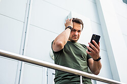 Symboldbild Cybermobbing - Verzweifelter Mann am Smartphone